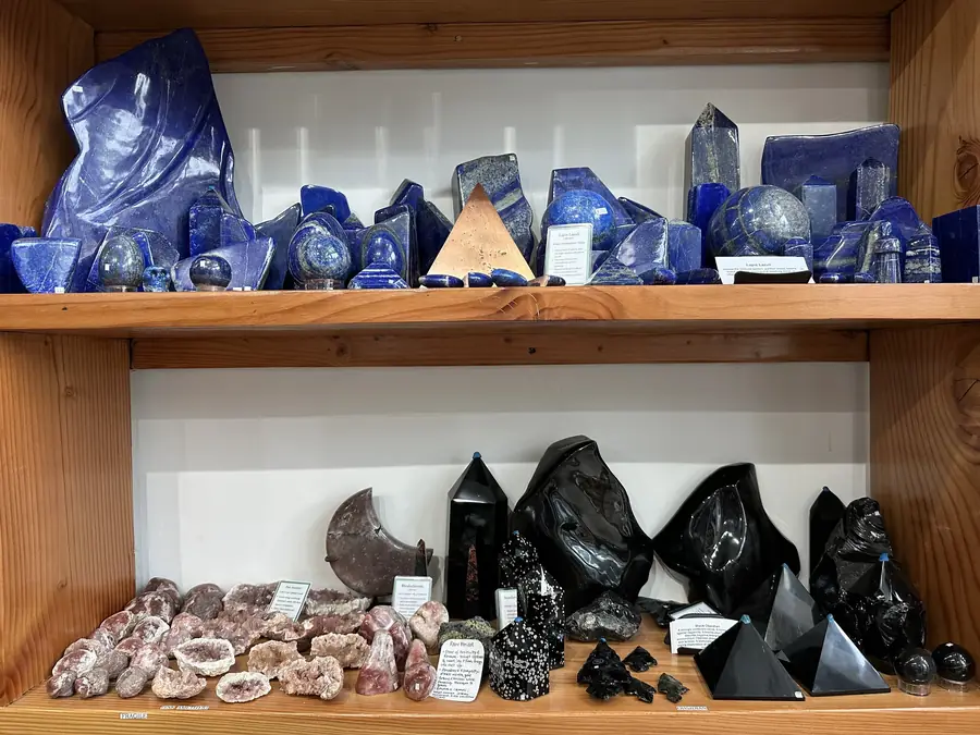 Lapis lazuli and obsidian carvings on wooden shelves