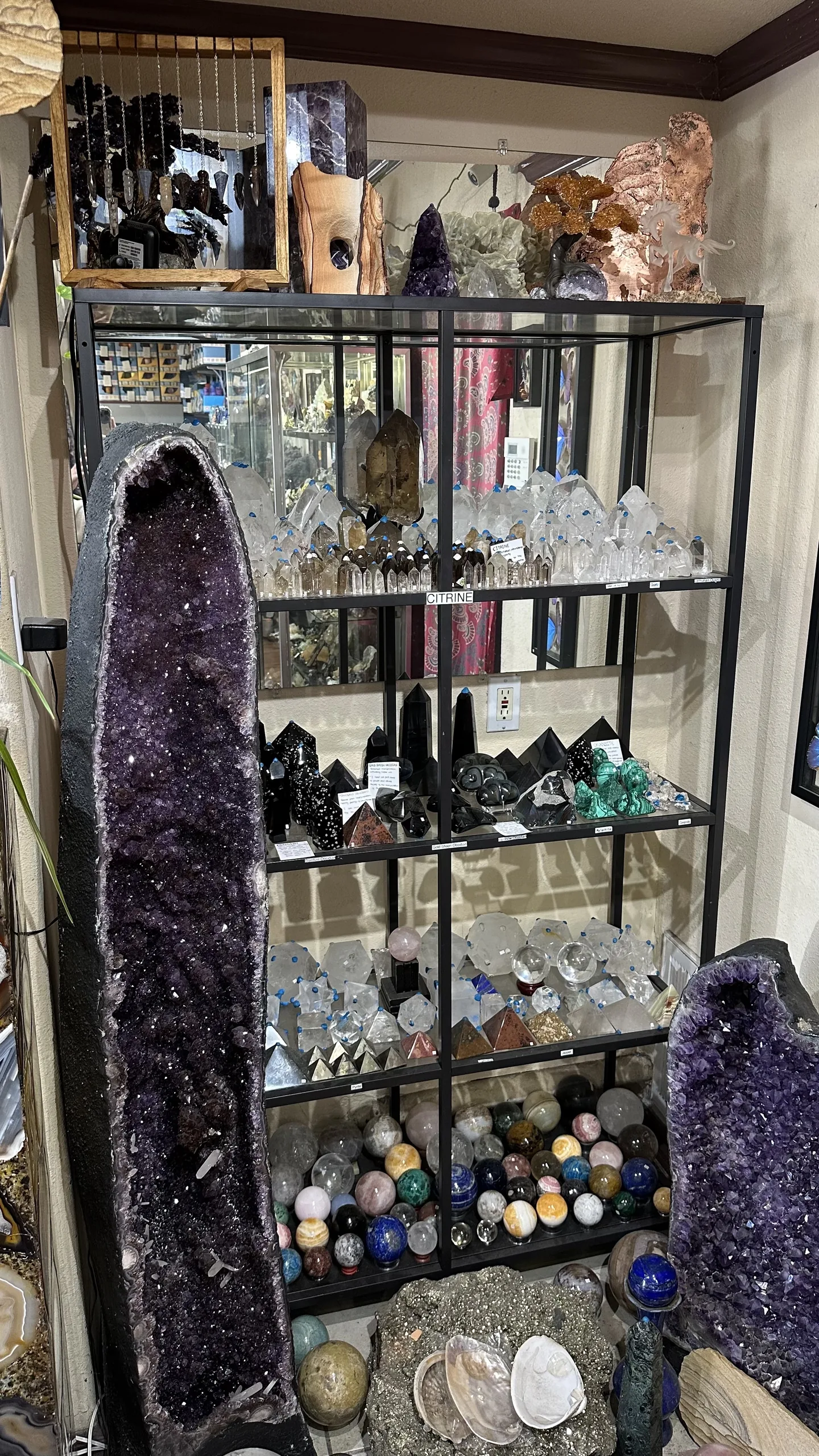 Amethyst cathedrals framing shelves of crystal points, pyramids and spheres at Stone Room